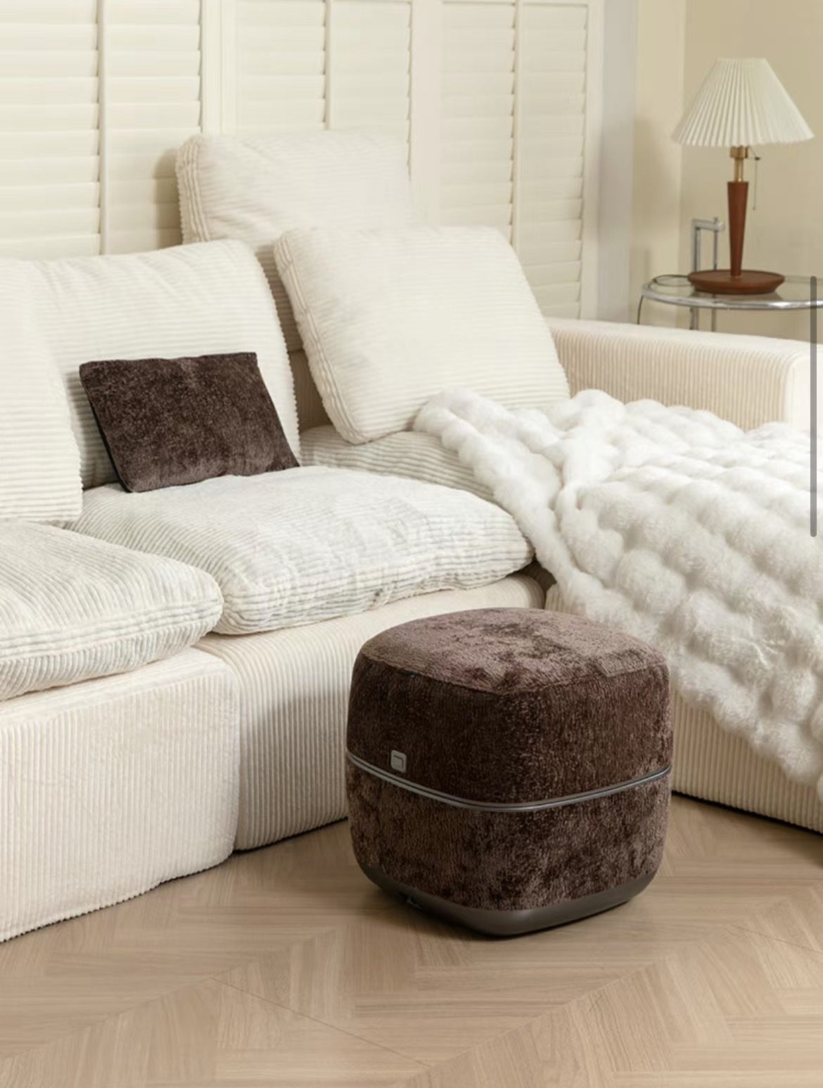 Brown SolePod Pro with its ottoman top closed beside a sofa